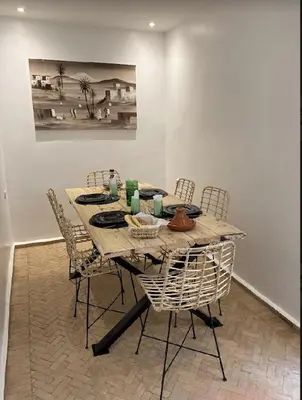 a dining room table with chairs and a painting on the wall at Riad KaBaYa Charme Exclusif Privatisé 2 à 8 Pers. in Marrakech