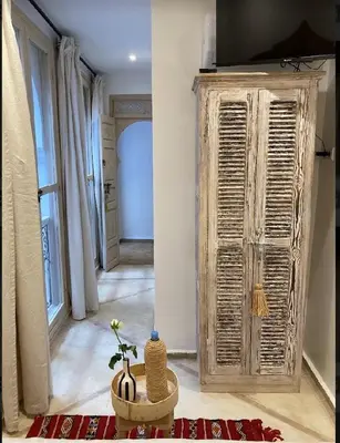 a living room with a large wooden cabinet and a room with at Riad KaBaYa Charme Exclusif Privatisé 2 à 8 Pers. in Marrakech