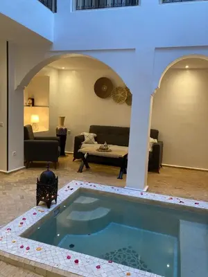 a living room with a swimming pool in the middle of a house at Riad KaBaYa Charme Exclusif Privatisé 2 à 8 Pers. in Marrakech