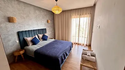 a bedroom with a bed with blue sheets and a window at Pearl Garden Studio Cozy Panoramic Charming sunny Terrace Piscine in Marrakech