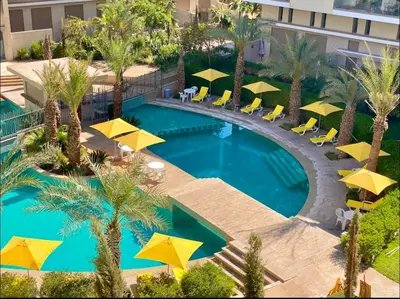 an overhead view of a swimming pool with yellow umbrellas at Pearl Garden Studio Cozy Panoramic Charming sunny Terrace Piscine in Marrakech