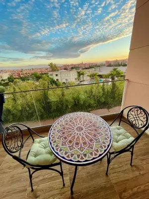a table and chairs on a balcony with a view at Pearl Garden Studio Cozy Panoramic Charming sunny Terrace Piscine in Marrakech