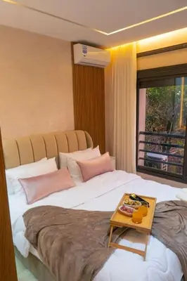 a bedroom with a large bed with a table on it at Appartement Marrakech Hivernage N2 RESIDENCE CAPRICE PALACE in Marrakech