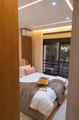 a bedroom with a large bed with a tray on it at Appartement Marrakech Hivernage N2 RESIDENCE CAPRICE PALACE in Marrakech