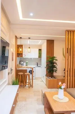 a living room with a table and a kitchen at Appartement Marrakech Hivernage N2 RESIDENCE CAPRICE PALACE in Marrakech