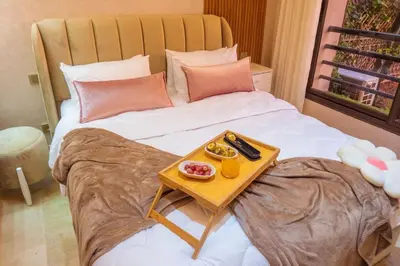 a bed with a tray of food on it at Appartement Marrakech Hivernage N2 RESIDENCE CAPRICE PALACE in Marrakech