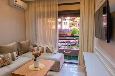 a living room with a couch and a table with a vase of flowers at Appartement Marrakech Hivernage N2 RESIDENCE CAPRICE PALACE in Marrakech
