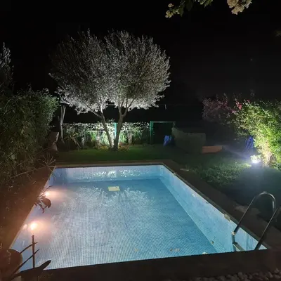 a swimming pool in a yard at night at Villa avec piscine chauffée & privée, 3 chambres in Sraghna