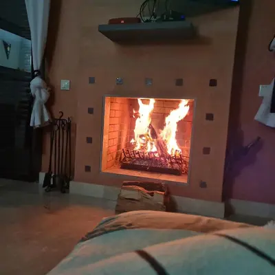 a fireplace in a room with fire in it at Villa avec piscine chauffée & privée, 3 chambres in Sraghna