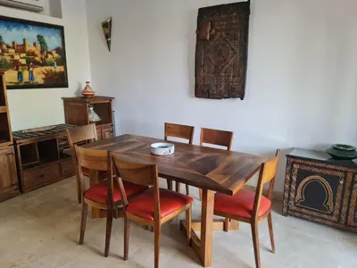 a dining room with a wooden table and chairs at Villa avec piscine chauffée & privée, 3 chambres in Sraghna