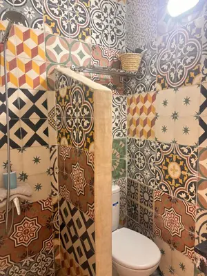 a bathroom with a toilet and a bunch of tiles at Riad Sanwa in Marrakech