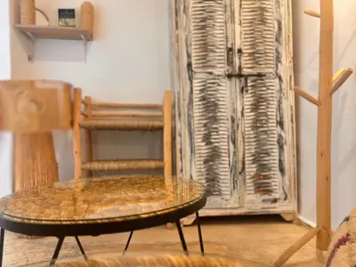 a table and a chair and a wooden cabinet at Riad Sanwa in Marrakech