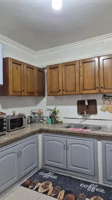 a kitchen with wooden cabinets and a kitchen rug at Lala's apartment in Marrakech