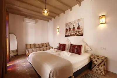 a bedroom with a large bed and a couch at Riad Darchica in Marrakech