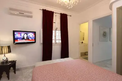 a bedroom with a bed and a tv on a wall at Riad avec piscine - Wifi- petit déjeuner - Bon Emplacement in Marrakech