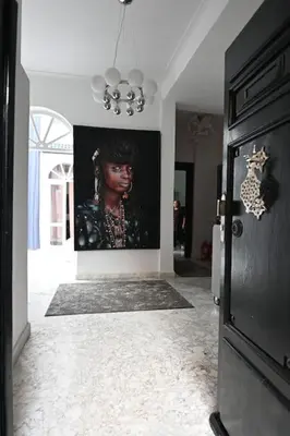 a hallway with a painting of a woman on the wall at Riad avec piscine - Wifi- petit déjeuner - Bon Emplacement in Marrakech