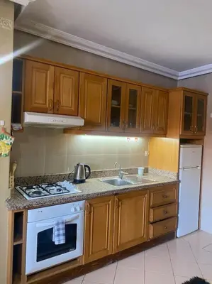 a kitchen with wooden cabinets and a white stove top oven at superbe appartement à Gueliz in Marrakech