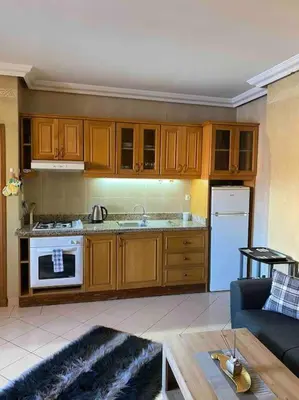 a kitchen with wooden cabinets and a stove top oven at superbe appartement à Gueliz in Marrakech