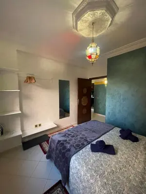 a bedroom with a bed and a chandelier at Appartement style Riad, 2 chambres, ambiance cosy in Marrakech