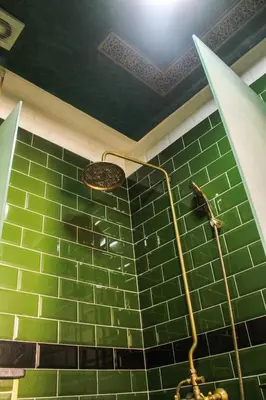 a bathroom with a shower with green tiles at Appartement style Riad, 2 chambres, ambiance cosy in Marrakech