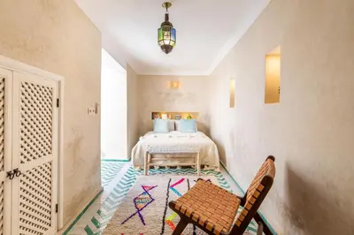 a bedroom with a bed and a table and a chair at Riad Itri (إتري) Exclusif - Marrocan Breakfast in Marrakech