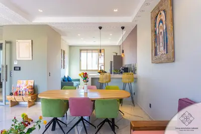 a dining room with a wooden table and colorful chairs at Villa Boutique Amani in Marrakech