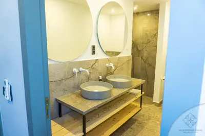 two sinks in a bathroom with two mirrors at Villa Boutique Amani in Marrakech