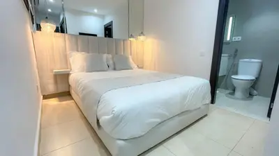 a bedroom with a white bed and a toilet at Villa Atlas piscine chauffée à Marrakech in Marrakech
