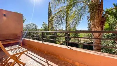 a balcony with a bench and a palm tree at Villa Atlas piscine chauffée à Marrakech in Marrakech