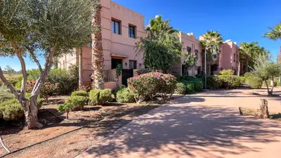 a building with trees and bushes in front of it at Villa Atlas piscine chauffée à Marrakech in Marrakech