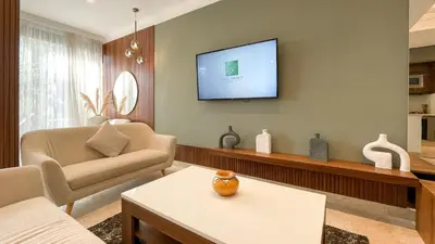 a living room with a couch and a tv on the wall at Villa Atlas piscine chauffée à Marrakech in Marrakech