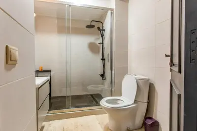 a bathroom with a toilet and a shower at Central Cosy Appartement Avec Piscine in Marrakech