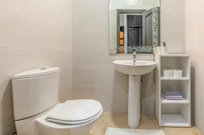 a white bathroom with a toilet and a sink at Central Cosy Appartement Avec Piscine in Marrakech