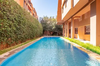 a swimming pool next to a building at Central Cosy Appartement Avec Piscine in Marrakech