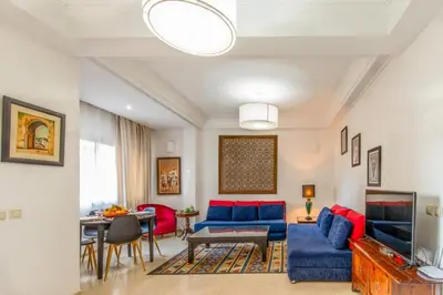 a living room with blue couches and a table at Central Cosy Appartement Avec Piscine in Marrakech