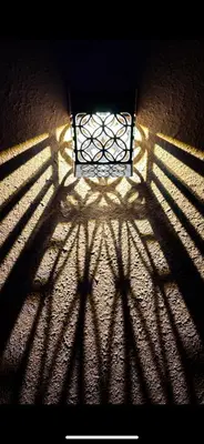 a shadow of a window on a wall with a gate at Dar Kamilya in Marrakech