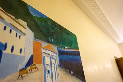 a mural of a beach on the wall of a building at Flowers riad in Marrakech