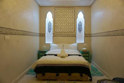 a bedroom with a bed with two lights above it at Flowers riad in Marrakech