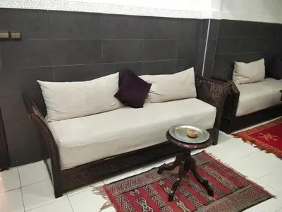 a couch with pillows and a table in a room at DAR IJLAL in Marrakech