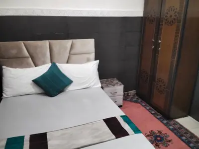 a bed with white pillows and a blue pillow at DAR IJLAL in Marrakech