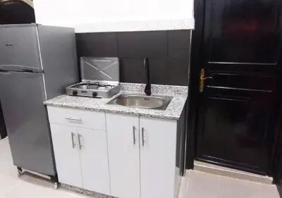 a kitchen with a sink and a black refrigerator at DAR IJLAL in Marrakech