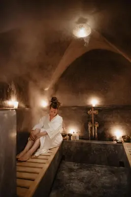 a woman sitting on a ledge in a bath tub at Riad BE Marrakech in Marrakech