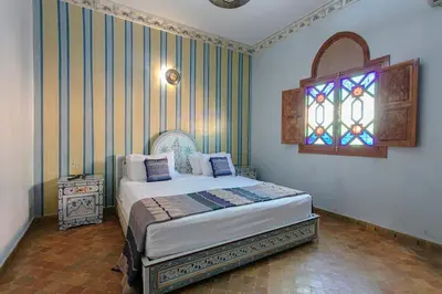 a bedroom with a bed and a stained glass window at Riad Tranquility - A Timeless Marrakech Haven in Marrakech