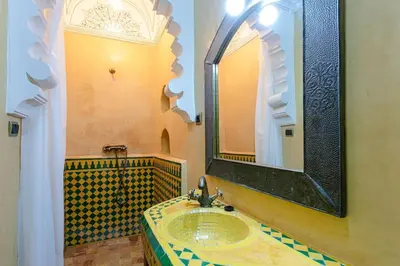 a bathroom with a sink and a large mirror at Riad Tranquility - A Timeless Marrakech Haven in Marrakech