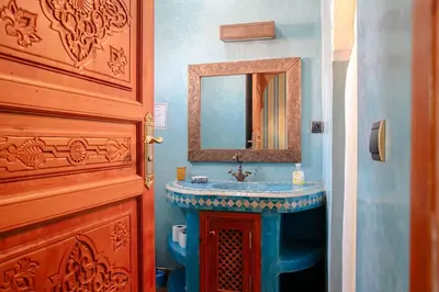 a bathroom with a blue sink and a mirror at Riad Tranquility - A Timeless Marrakech Haven in Marrakech