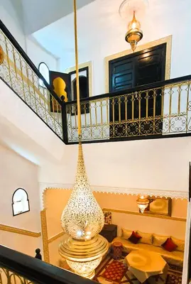 a large glass vase hanging from a staircase at Quarya Assiyahia - Riad CAMILIA- Maison entière avec piscine in Marrakech