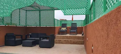 a group of chairs sitting on top of a building at Quarya Assiyahia - Riad CAMILIA- Maison entière avec piscine in Marrakech