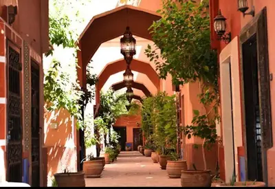 an alley with an archway with potted plants on it at Quarya Assiyahia - Riad CAMILIA- Maison entière avec piscine in Marrakech