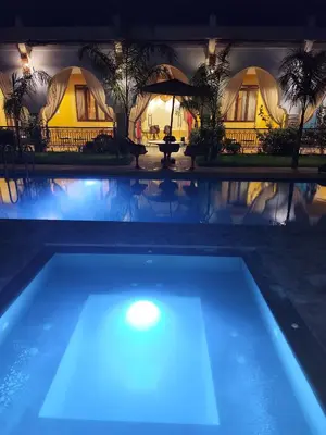 a swimming pool at night with tents in the background at Riad Safran Ralya in Marrakech