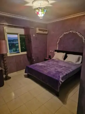 a bedroom with a purple bed and a window at appartement sympathique à Marrakech in Marrakech